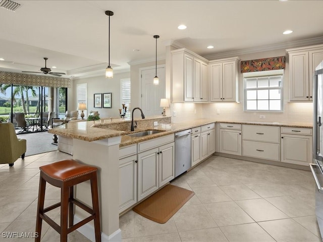 kitchen featuring ceiling fan, pendant lighting, stainless steel dishwasher, kitchen peninsula, and sink