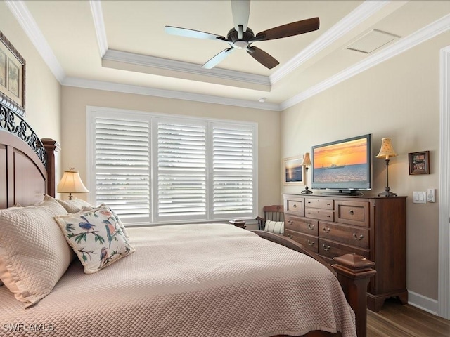 bedroom featuring ceiling fan, ornamental molding, a raised ceiling, and hardwood / wood-style flooring