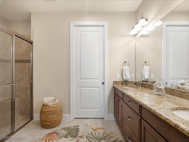 bathroom featuring a shower with door, vanity, and tile patterned flooring