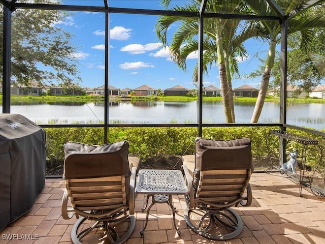 sunroom featuring a water view