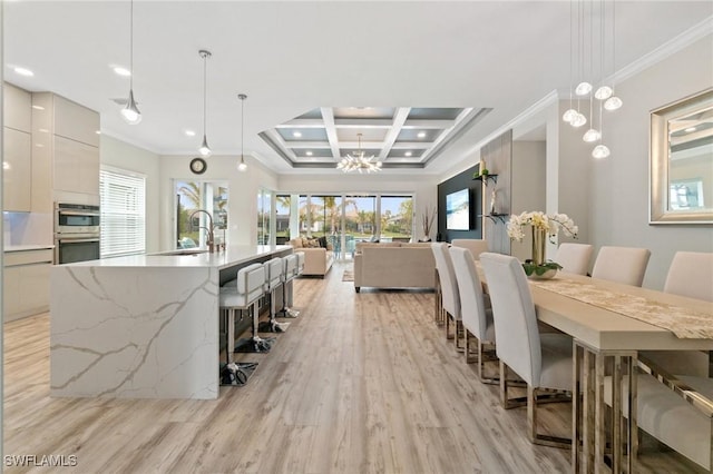 dining room featuring coffered ceiling, sink, light hardwood / wood-style flooring, ornamental molding, and beamed ceiling