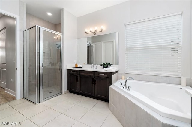 bathroom featuring independent shower and bath, vanity, and tile patterned floors