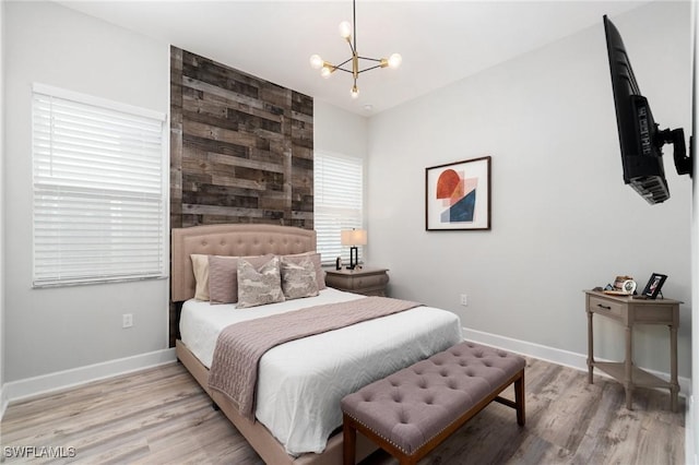 bedroom featuring a chandelier and light wood-type flooring