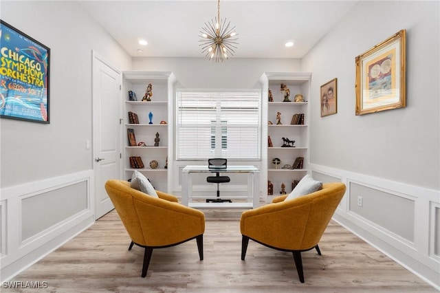 living area featuring light wood-type flooring, a chandelier, a decorative wall, and recessed lighting