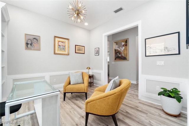 living area featuring an inviting chandelier and light hardwood / wood-style floors