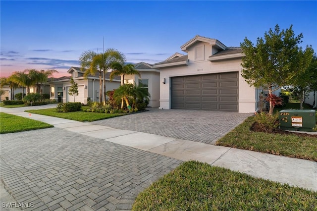 ranch-style home featuring a garage and a lawn