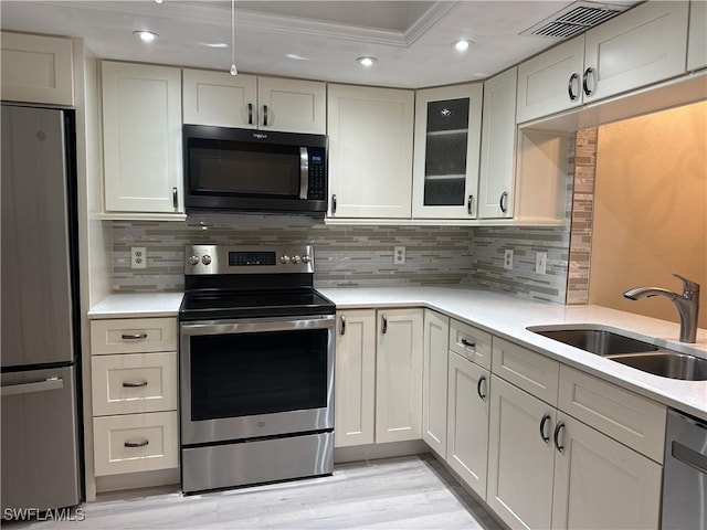 kitchen featuring decorative backsplash, sink, appliances with stainless steel finishes, and crown molding