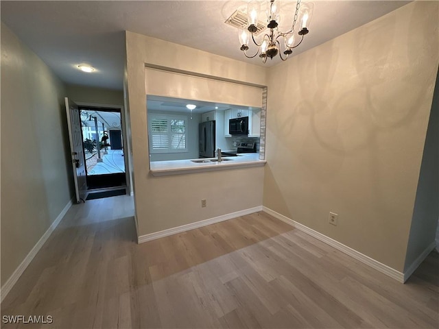 interior space featuring a notable chandelier, sink, and hardwood / wood-style floors