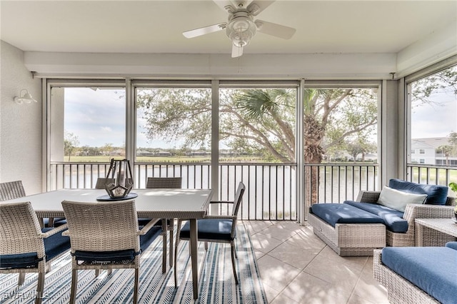 sunroom with a water view and ceiling fan