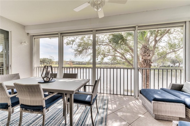 sunroom featuring a water view and ceiling fan