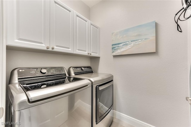 laundry room with cabinets and washing machine and clothes dryer