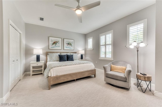 carpeted bedroom featuring ceiling fan and a closet