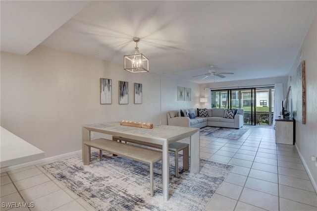 tiled dining space with ceiling fan with notable chandelier