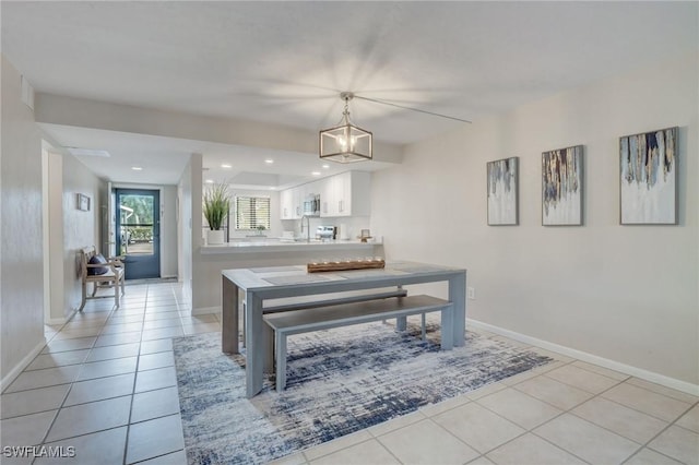 dining room with an inviting chandelier, light tile patterned flooring, and sink