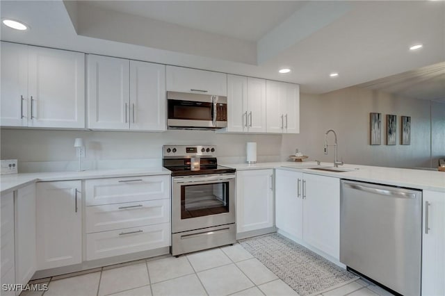 kitchen featuring white cabinets, sink, light tile patterned floors, and stainless steel appliances