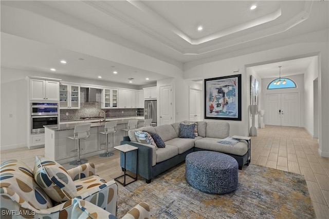 living room featuring a raised ceiling and light hardwood / wood-style flooring