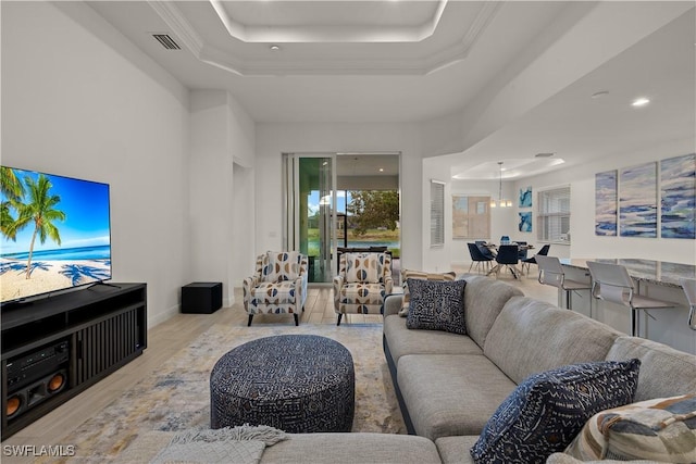 living room featuring a raised ceiling and light wood-type flooring