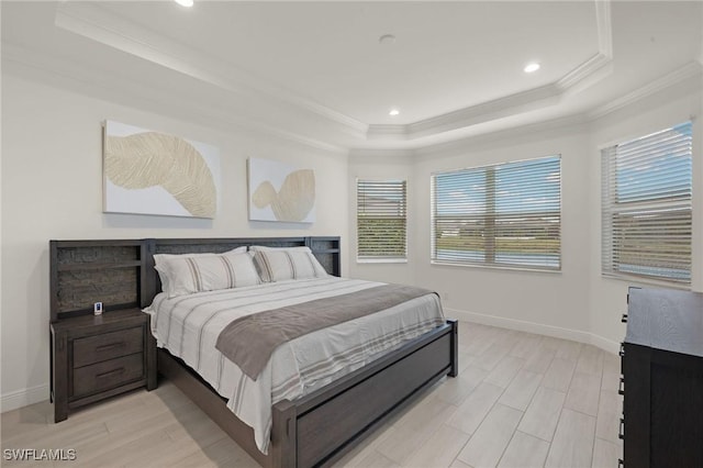 bedroom featuring light hardwood / wood-style floors, ornamental molding, and a raised ceiling