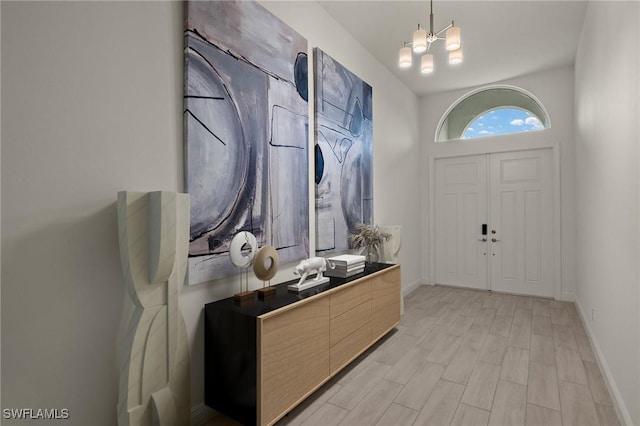 foyer entrance featuring an inviting chandelier and light wood-type flooring