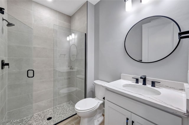 bathroom with walk in shower, vanity, and toilet