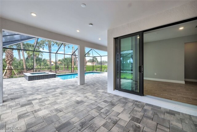 view of pool featuring glass enclosure, a patio area, and an in ground hot tub