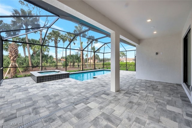 view of pool featuring a lanai, a patio area, and an in ground hot tub