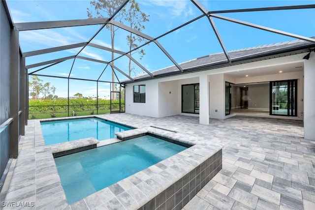 view of pool featuring an in ground hot tub, a lanai, and a patio area