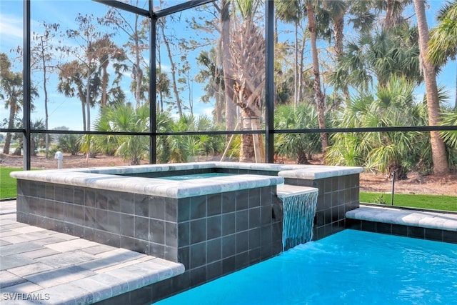 view of pool featuring glass enclosure and a jacuzzi