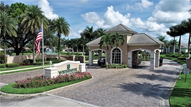 view of home's community with decorative driveway and a gate