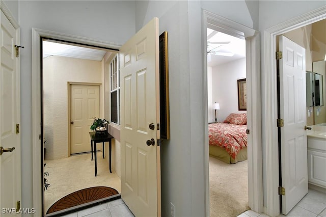 hallway with light carpet and light tile patterned floors