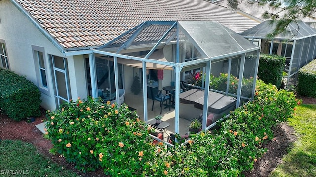 exterior space with a patio area, a lanai, a tile roof, and stucco siding