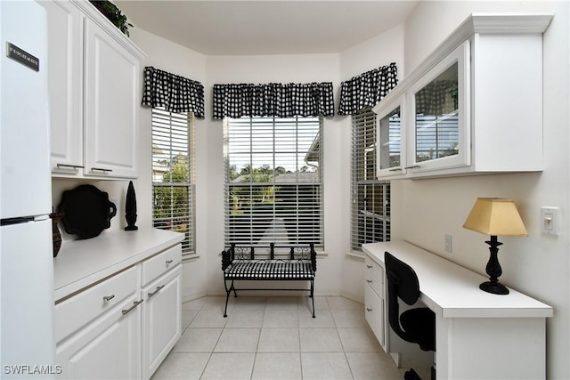 office space featuring light tile patterned floors and built in study area