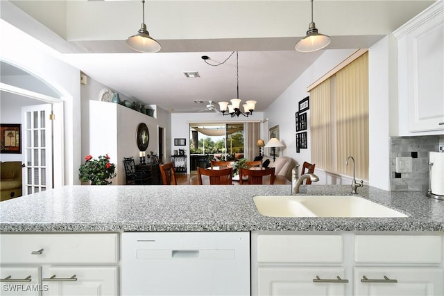 kitchen featuring tasteful backsplash, visible vents, open floor plan, white dishwasher, and a sink