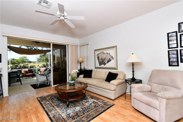 living area featuring visible vents, ceiling fan, and wood finished floors