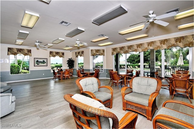 interior space featuring a ceiling fan, visible vents, and ornamental molding