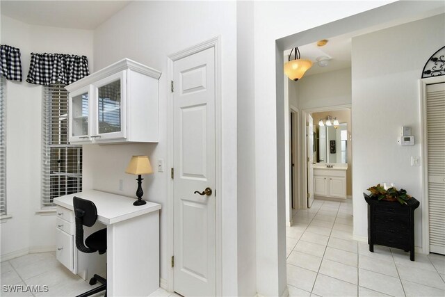 home office with baseboards and light tile patterned floors