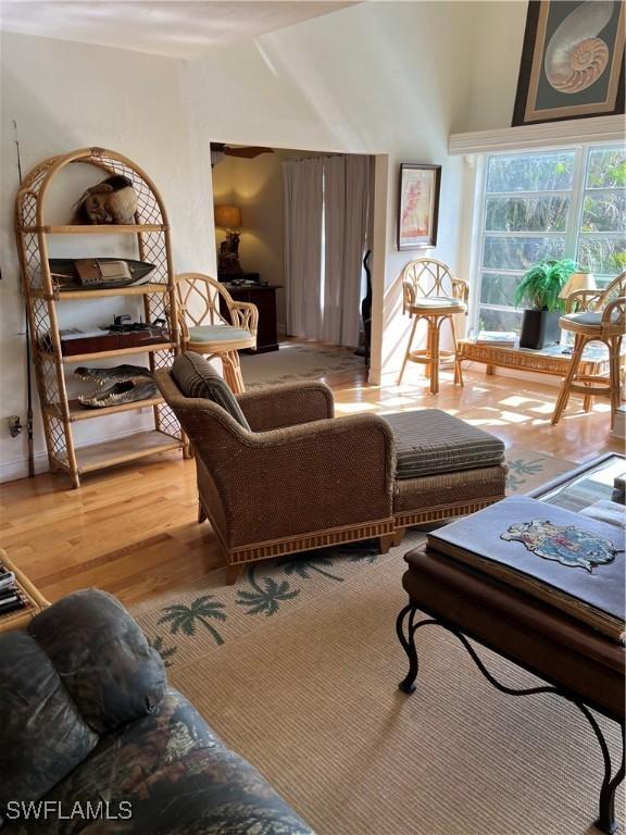 sitting room with vaulted ceiling and light wood-style flooring