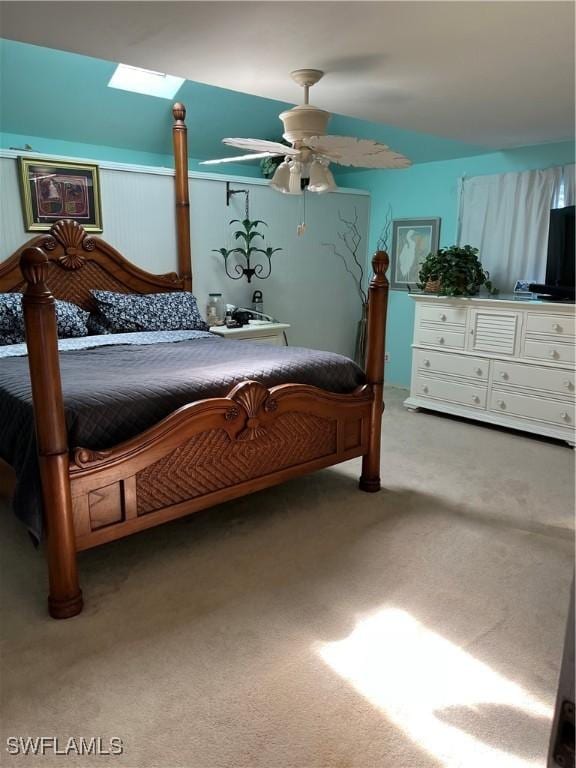 bedroom with ceiling fan, light colored carpet, and a skylight