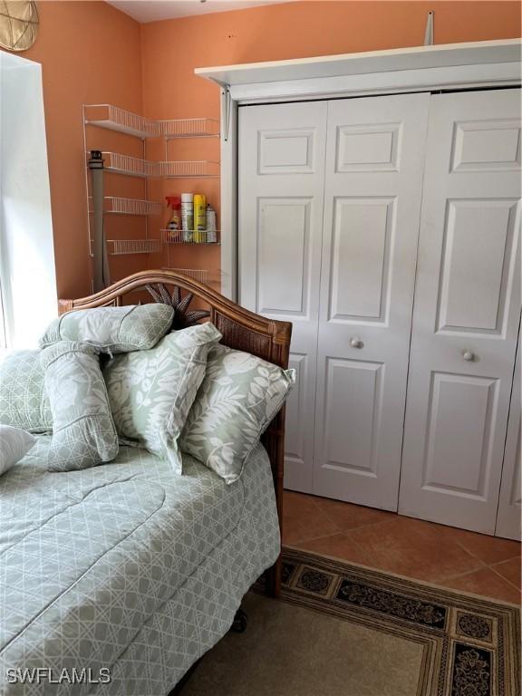 bedroom with tile patterned floors and a closet