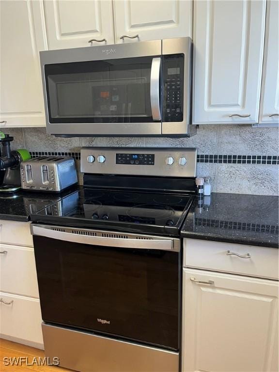 kitchen with white cabinets, stainless steel appliances, and decorative backsplash