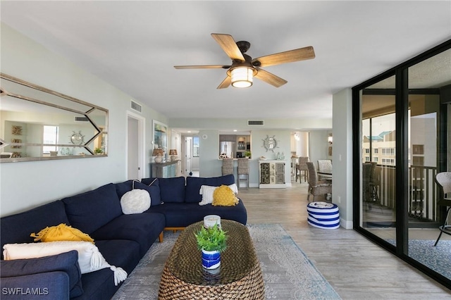 living room with ceiling fan and hardwood / wood-style floors