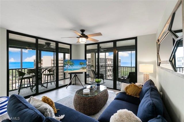 living room with a healthy amount of sunlight, floor to ceiling windows, and hardwood / wood-style floors