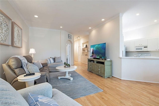 living room featuring built in features, ornamental molding, and light hardwood / wood-style flooring