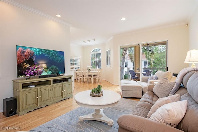 living room with light wood-type flooring, ornamental molding, recessed lighting, and baseboards