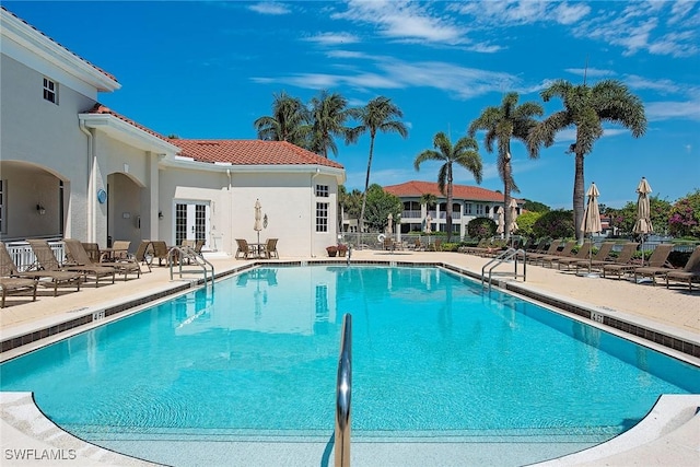 community pool featuring french doors and a patio