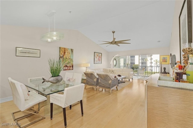 dining room with ceiling fan, vaulted ceiling, and light hardwood / wood-style flooring