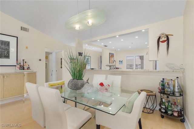 dining area with vaulted ceiling and light hardwood / wood-style floors