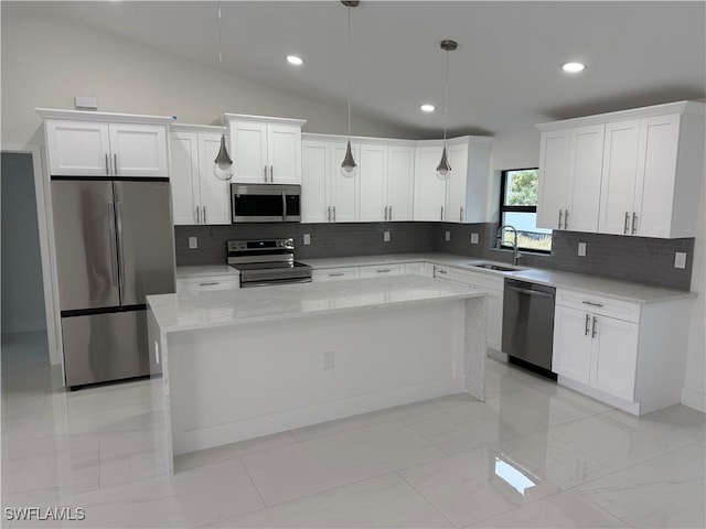 kitchen with stainless steel appliances, decorative backsplash, decorative light fixtures, vaulted ceiling, and a center island