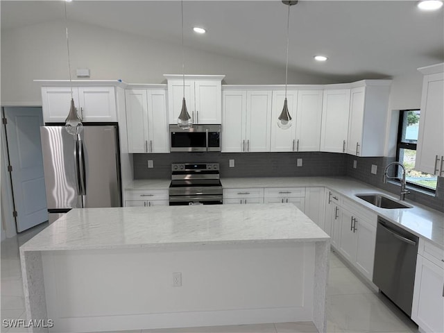 kitchen featuring decorative light fixtures, lofted ceiling, backsplash, sink, and appliances with stainless steel finishes