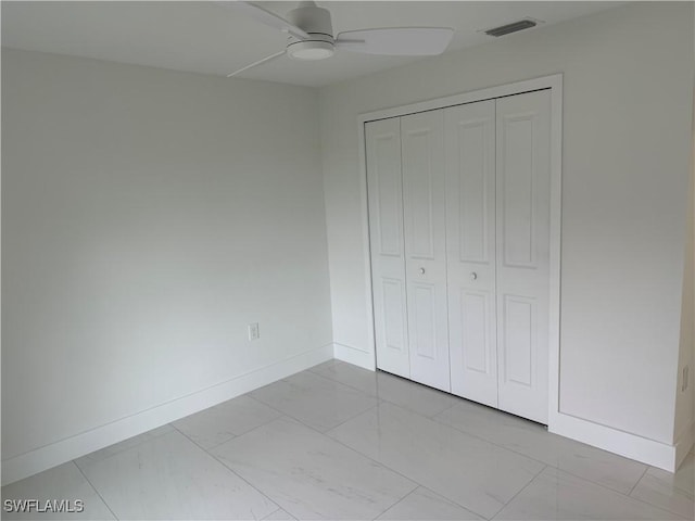 unfurnished bedroom with ceiling fan and a closet